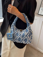 sac bleu brodee effilochee en jeans tenu par la main gauche femme elegante