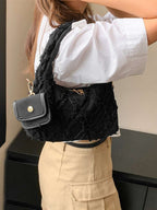 sac noir style effilochee brodee femme portant sur l'epaule droite